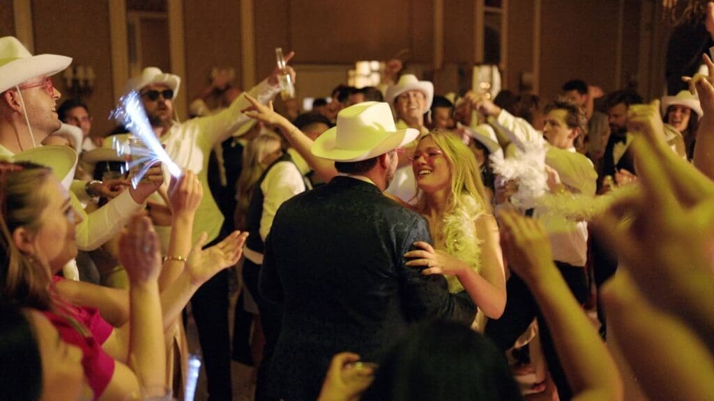 Bride and groom dancing surrounded by guests in white cowboy hats at The Broadmoor Denver wedding reception.