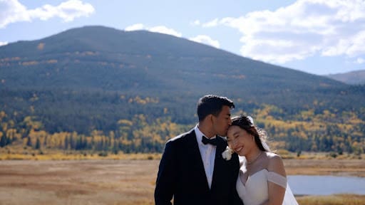 Rahul Madduluri kissing Reia Cho on the forehead during wedding portraits in Rocky Mountain National Park, Colorado