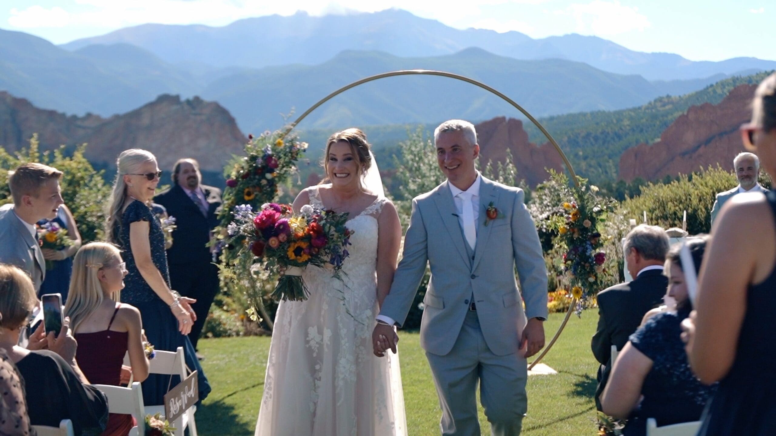 Couple standing on a mountain overlook during a Colorado elopement with cinematic mountain scenery at sunrise