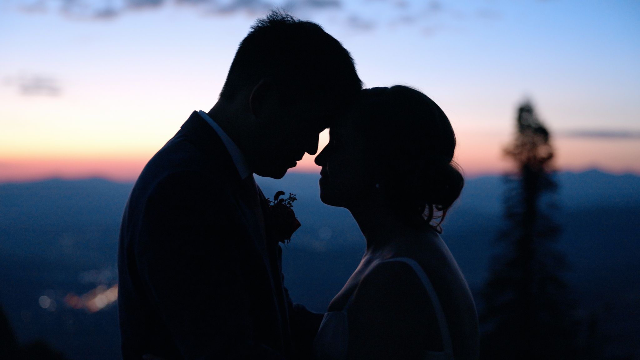 Silhouette of a couple embracing at sunset with the Colorado mountains in the background, from an Ampersand Family wedding video